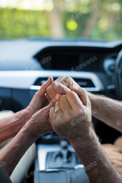 Preview: Senior couple holding hands in car