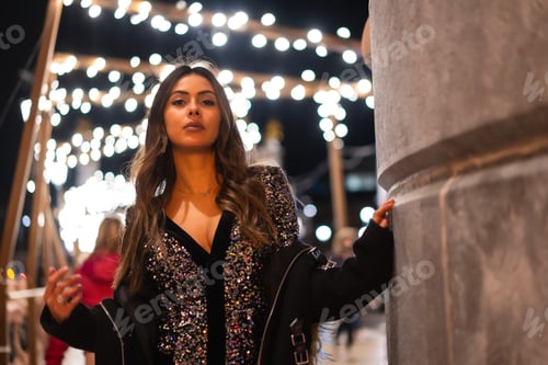 Preview: Young girl in a fashionable dress with sequins in the city christmas lights
