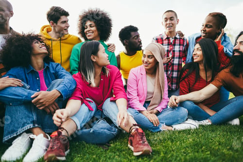 Preview: Happy diverse people having fun outdoor sitting on grass at city park - Focus on asian girl face