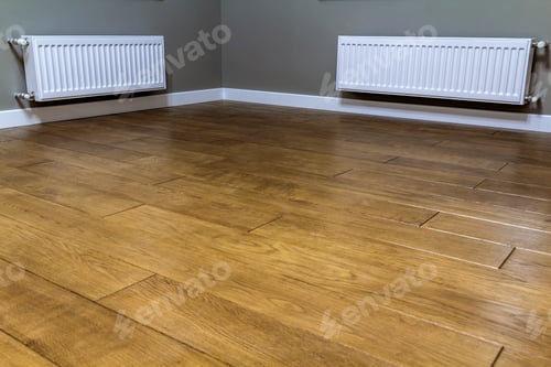 Preview: White heating radiators on wall in an apartment with wooden floor