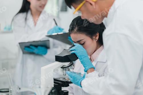 Preview: Scientist examining biological samples under a microscope in medical research laboratory