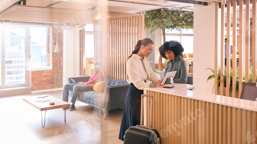 Preview: Businesswoman With Suitcase Checking In At Hotel Reception For Conference