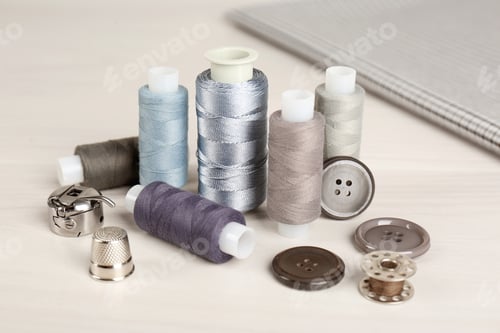 Preview: Composition with different sewing items and fabric on light beige table