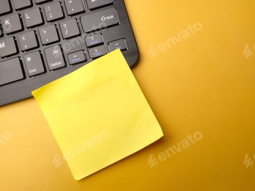 Preview: Top view of a wireless keyboard, and a blank colored sticky note with copy space