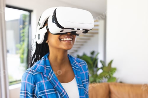 Preview: Young African American woman wears a virtual reality headset, smiling in a bright room