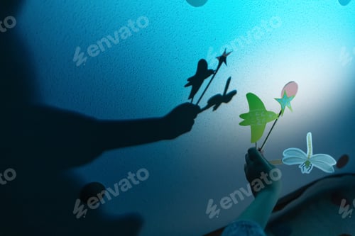 Preview: Crop child holding paper bird and fly in light creating shadow