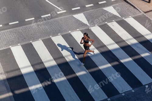 Preview: Young woman running on zebra crossing