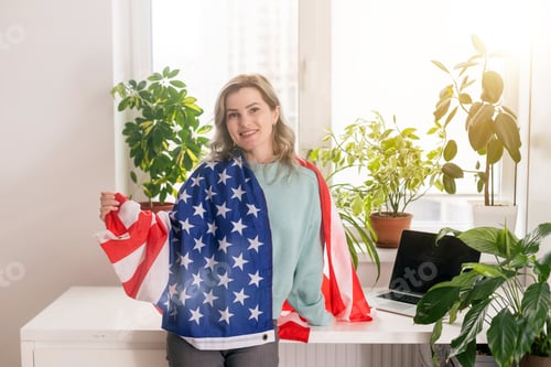 Preview: Positive teacher in headset having online lesson on laptop near flags in school