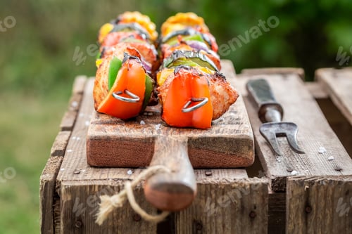Preview: Healthy grilled skewers served with water in summer garden