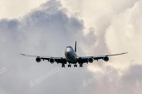 Preview: Jet airliner is descending towards an airport. The plane is flying through a cloudy sky.
