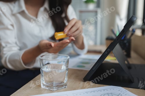 Preview: Woman taking morning medicine with water during work