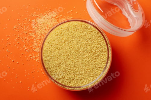 Preview: Glass jar with couscous on orange background