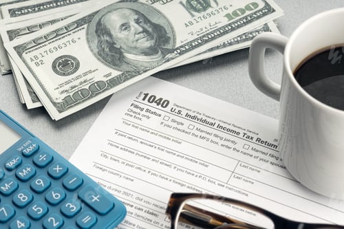 Preview: Tax form, calculator, eyeglasses and money on desk