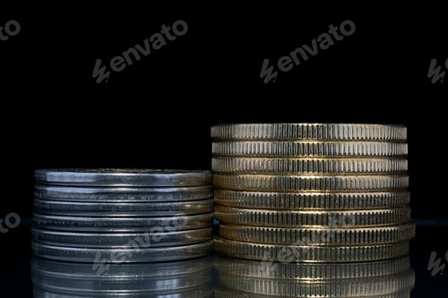 Preview: Two stacks of coins, one silver and one gold, on a black background