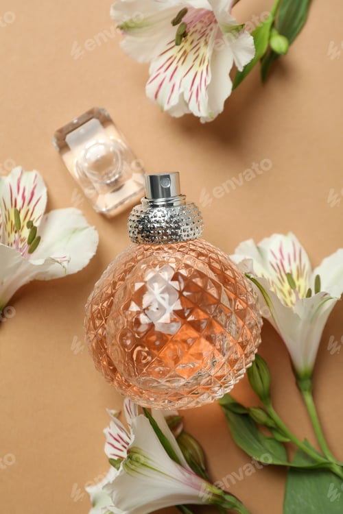 Preview: Perfume and flowers on beige background, close up