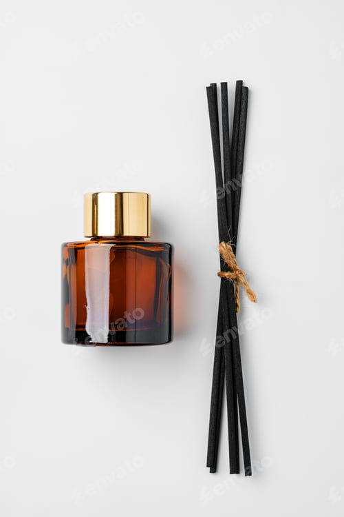 Preview: A minimalist display of essential oil and black diffuser sticks on a clean white background