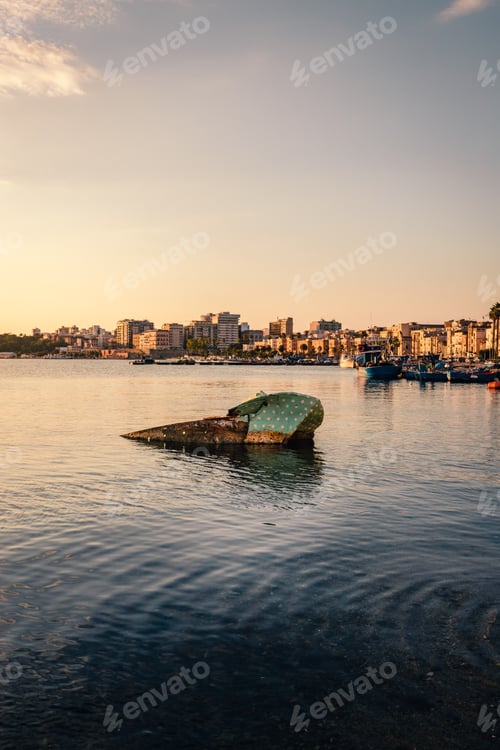 Preview: Boat sunk in the port of Taranto Vecchia with the city of Taranto behind it