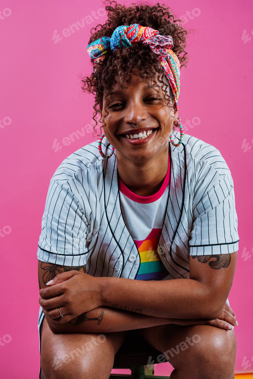 Preview: Young woman wearing sunglasses and headscarf is smiling on pink background