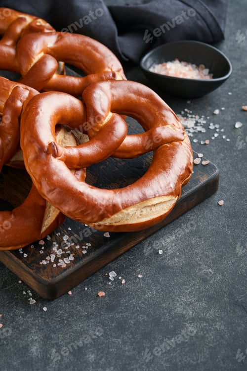 Preview: Oktoberfest concept card. Traditional Bavarian pretzels with beer bottle mug on old dark black rusti