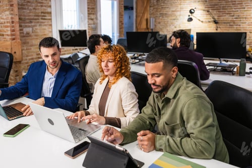 Preview: Multi ethnic team collaborating on project in modern office