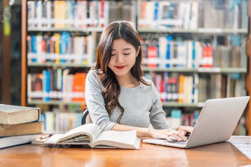 Preview: Asian young Student in casual suit doing homework and using technology laptop