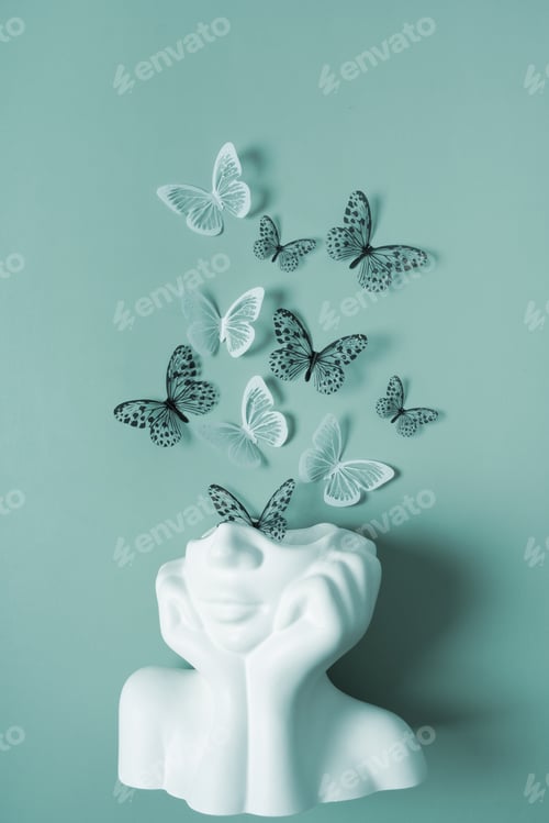 Preview: A figurine of a head with butterflies on a colored background. Mental health concept