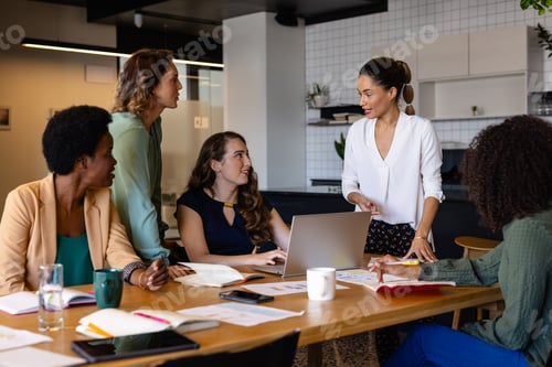 Preview: Diverse female colleagues in discussion using laptop in casual meeting in office