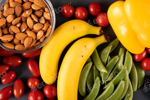 Preview: Overhead view of almonds with tomatoes, bananas and vegetables on table