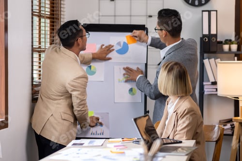Preview: Group of confident business people point to graphs and charts to analyze market data, balance sheet,