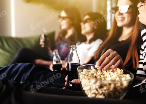 Preview: Group of people are watching a movie. Friend girls eat popcorn and drink soda