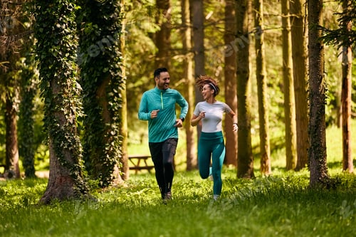 Preview: Full length of happy sports couple running together in nature.