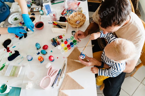 Preview: Happy Easter! Father with son painting eggs at home.