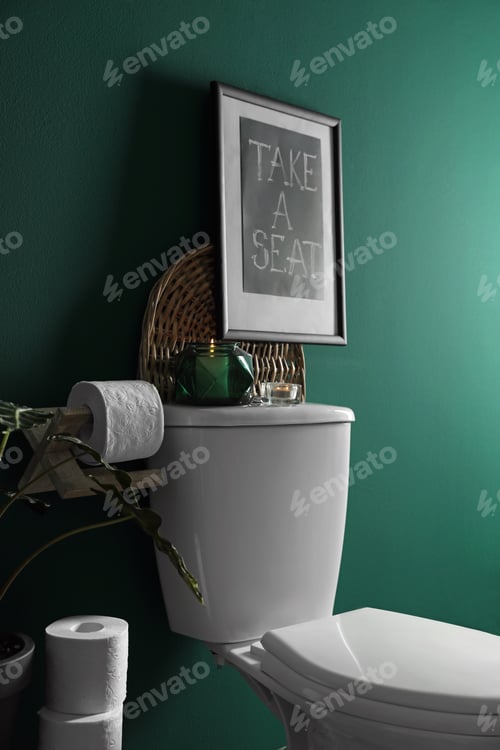 Preview: Decor elements, paper rolls and toilet bowl near green wall. Bathroom interior