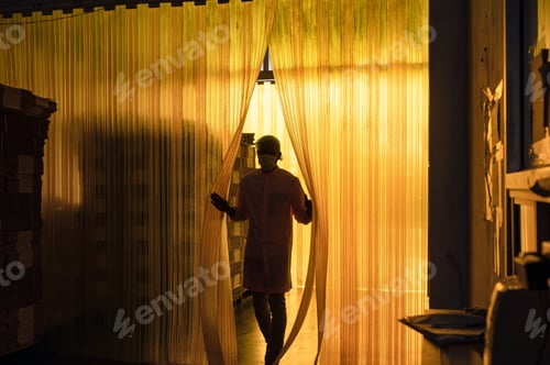 Visualização: Trabalhador africano do sexo masculino abrindo cortina de plástico em armazém de embalagens de papelão