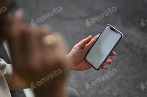 Preview: Closeup view middle age man checking social media on smartphone in the public park
