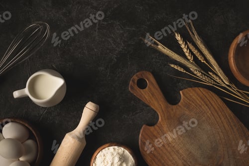 Preview: flat lay with raw eggs, flour and various kitchen utensils for bakery isolated on black surface