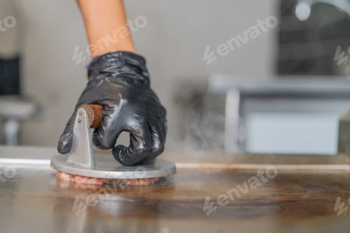 Preview: Making smash burgers on the restaurant griddle by smashing them with a utensil