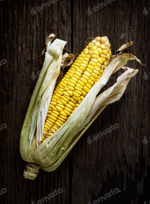 Preview: Aerial view of sweencorn cob on wooden background