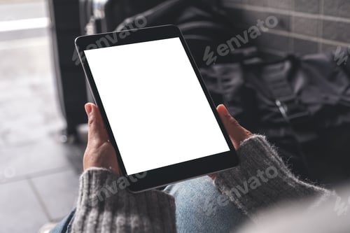 Preview: A woman holding and using black tablet pc with blank white desktop screen with baggages