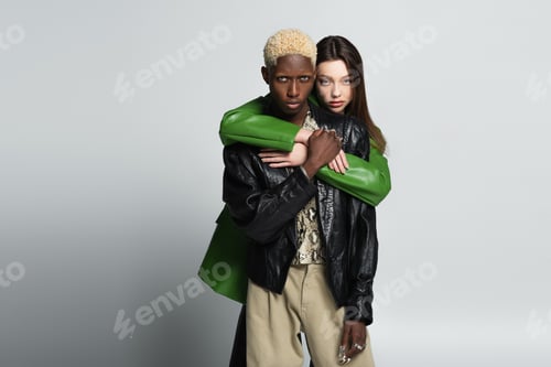 Preview: brunette woman hugging african american man with bleached hair on grey
