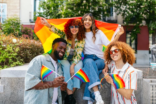 Preview: Group of diverse friends celebrating lgbt pride month with rainbow flags