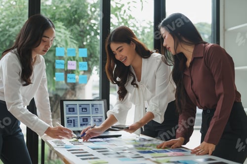 Preview: Web designers working on photo contact sheets and wireframes in modern office
