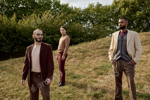 Preview: Handsome men in stylish autumn attire pose together in a vibrant autumn field