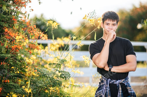 Preview: The male traveler wears a black shirt and stands in a flower garden.