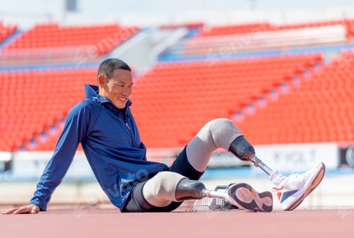 Preview: Sport man athlete with a prosthesis on his leg sit on the track and look forward to relax
