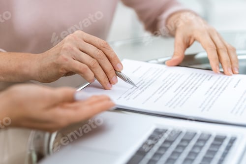 Preview: Hand of mature woman pointing at one of contract points