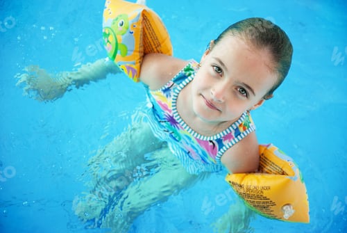 Preview: little girl learning to swim in the pool