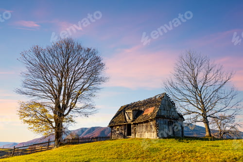 Preview: Old wooden house built on grassy hill against mountains