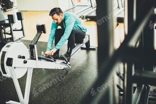 Preview: Young man exercise on an exercise machine at the gym