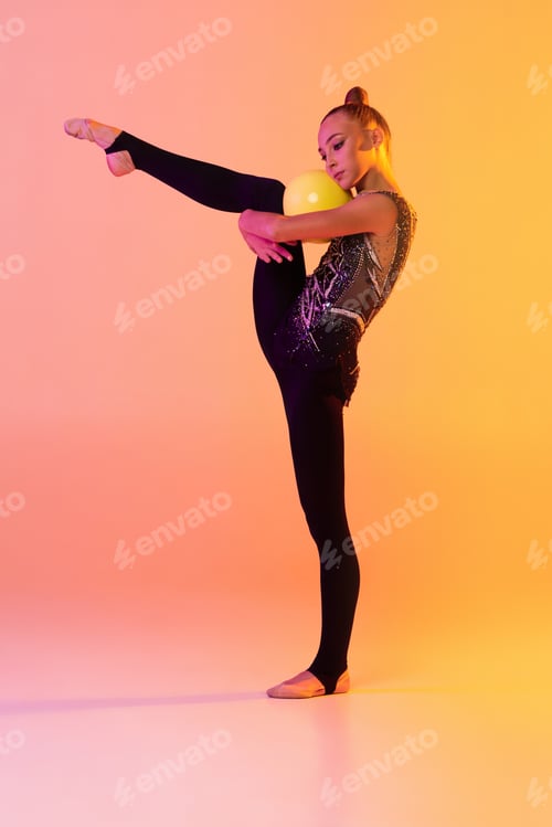 Preview: Portrait of little girl, rhythmic gymnastics artist isolated on pink yellow studio background in